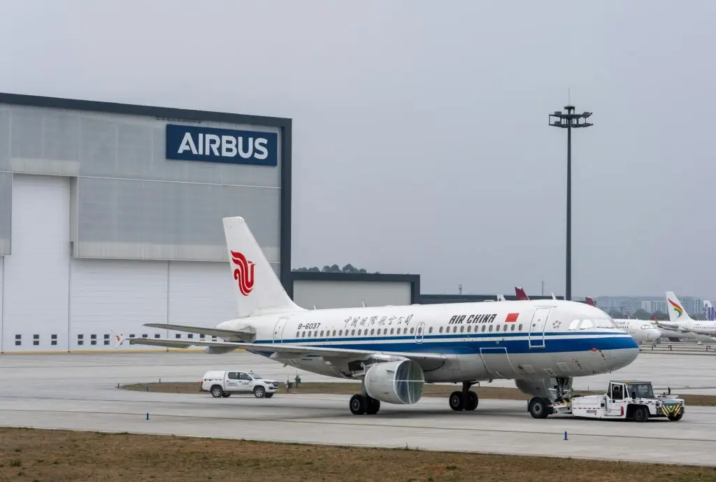 Air China Airbus A320 parked at Airbus hangar, showcasing aviation industry infrastructure.