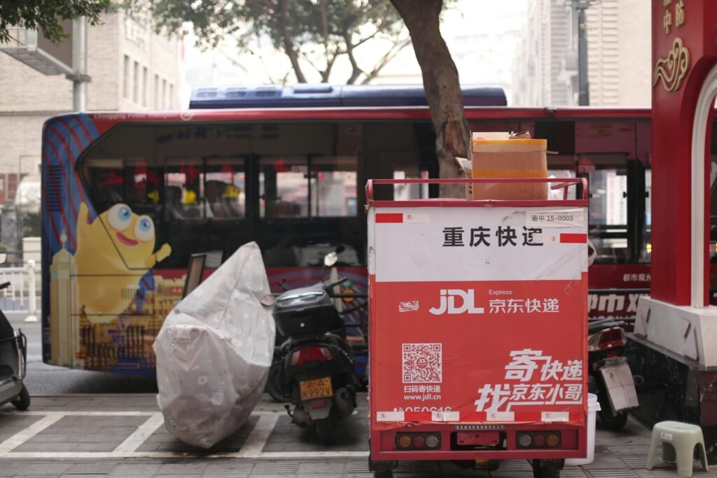 A JD Express delivery scooter parked in a bustling Asian city street.