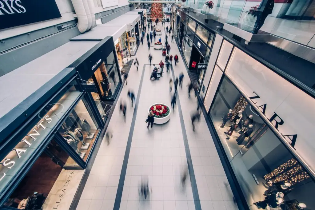 A vibrant scene capturing a busy shopping mall with modern stores and diverse shoppers on the move.